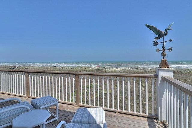 deck with a view of the beach and a water view