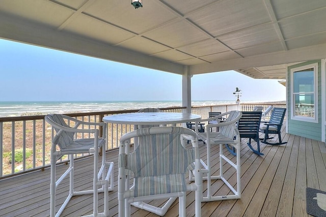 wooden deck featuring a water view and a view of the beach