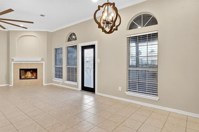 15341 Yardarm Ct, Corpus Christi, TX 78418 - unfurnished living room with ceiling fan, light tile patterned floors, a chandelier, a tile fireplace, and ornamental molding