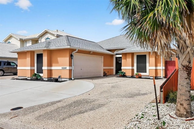 15341 Yardarm Ct, Corpus Christi, TX 78418 - view of front of house featuring stucco siding, roof with shingles, concrete driveway, and an attached garage