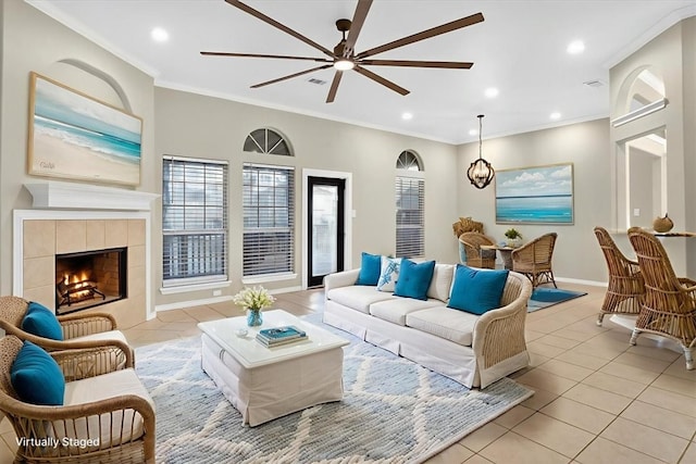 15341 Yardarm Ct, Corpus Christi, TX 78418 - living room featuring ceiling fan, light tile patterned floors, crown molding, a tiled fireplace, and recessed lighting