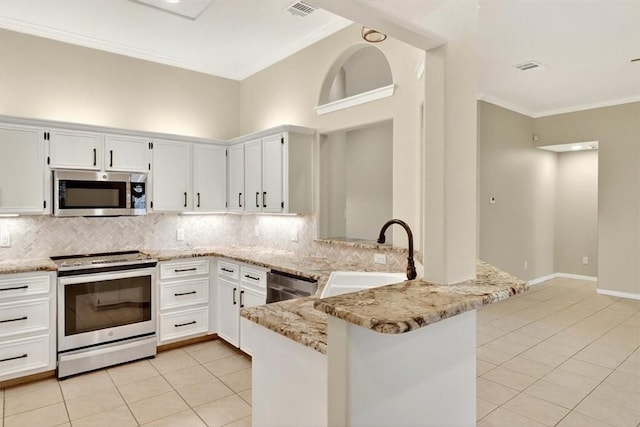 15341 Yardarm Ct, Corpus Christi, TX 78418 - kitchen featuring stainless steel appliances, light tile patterned floors, a peninsula, tasteful backsplash, and crown molding