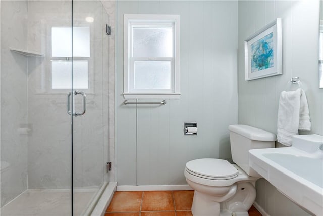 full bathroom featuring toilet, tile patterned floors, a stall shower, and baseboards