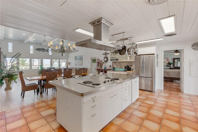 kitchen featuring freestanding refrigerator, white cabinetry, a kitchen island, white electric cooktop, and island exhaust hood