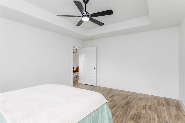 2513 Luzius Dr, Corpus Christi, TX 78418 - bedroom featuring a raised ceiling, wood finished floors, baseboards, and ceiling fan