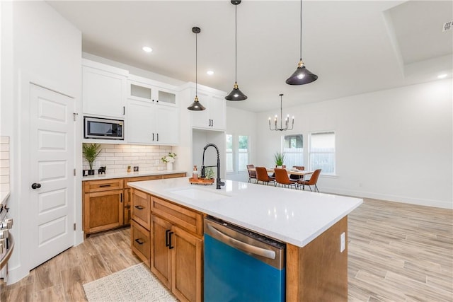 2513 Luzius Dr, Corpus Christi, TX 78418 - kitchen with dishwasher, a sink, stainless steel microwave, light wood-style floors, and a chandelier