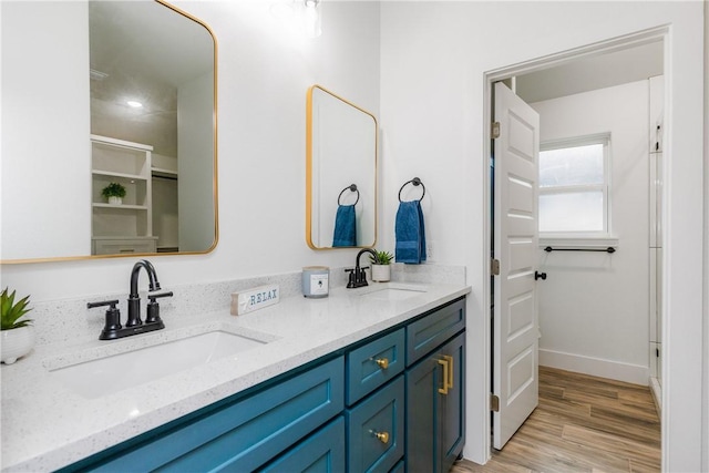 2513 Luzius Dr, Corpus Christi, TX 78418 - bathroom featuring double vanity, wood finished floors, and baseboards