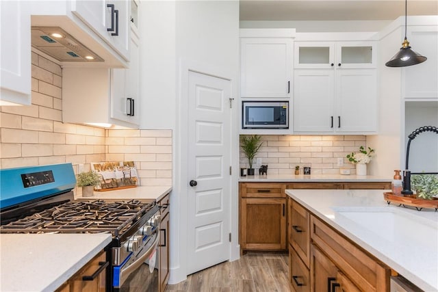 2513 Luzius Dr, Corpus Christi, TX 78418 - kitchen featuring stainless steel appliances, a sink, white cabinetry, and pendant lighting