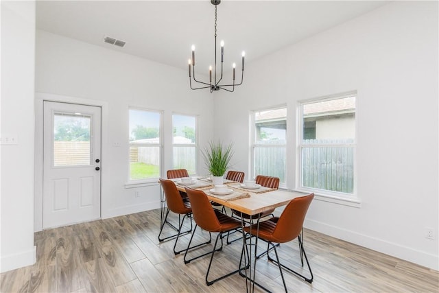 2513 Luzius Dr, Corpus Christi, TX 78418 - dining space featuring a chandelier, light wood-style flooring, and baseboards