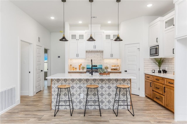 2513 Luzius Dr, Corpus Christi, TX 78418 - kitchen featuring stainless steel appliances, a breakfast bar, light countertops, light wood-style flooring, and recessed lighting
