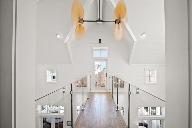 hall featuring a high ceiling and wood-type flooring