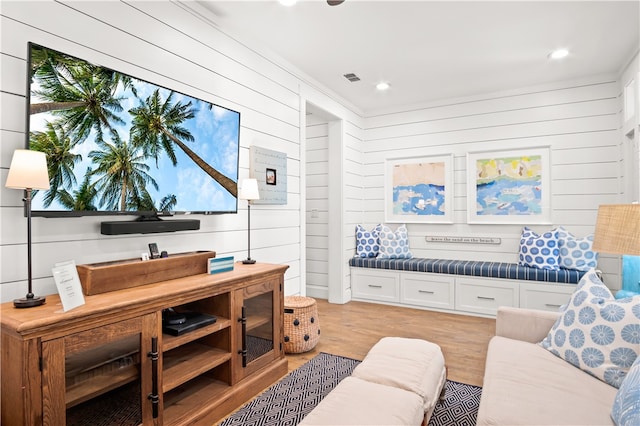 living room featuring wooden walls and light hardwood / wood-style floors