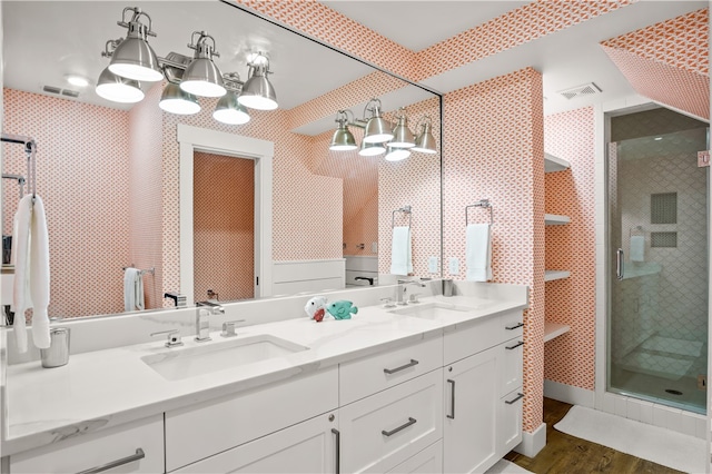 bathroom featuring hardwood / wood-style floors, a shower with door, and vanity