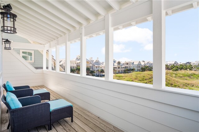 sunroom featuring plenty of natural light and lofted ceiling with beams