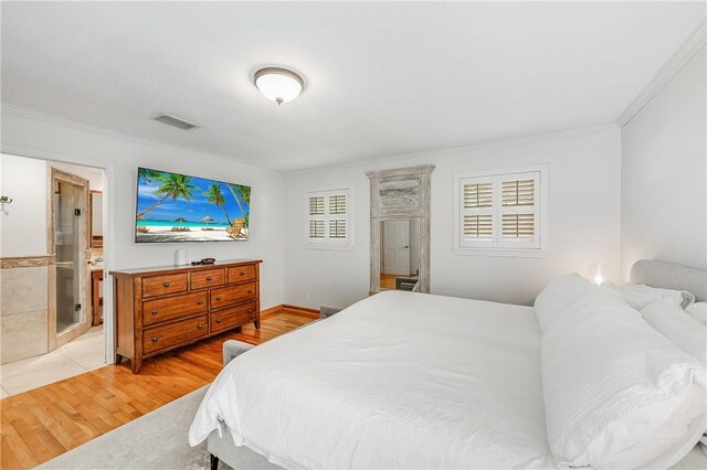 bedroom with ornamental molding, light wood-style flooring, and ensuite bathroom