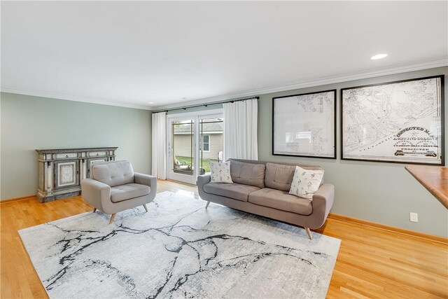living room featuring ornamental molding, light wood-style floors, and baseboards