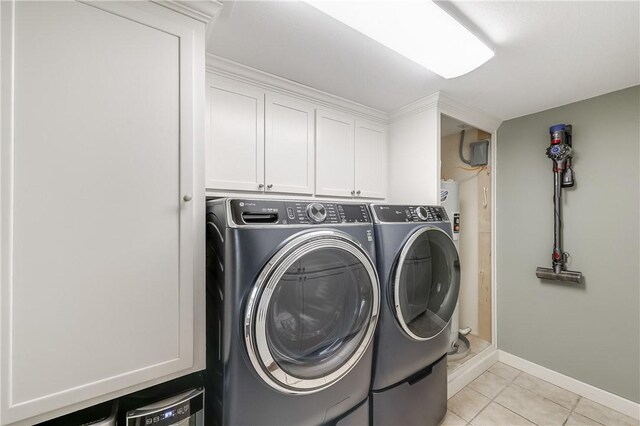 laundry room featuring washer and dryer, light tile patterned floors, baseboards, and cabinet space