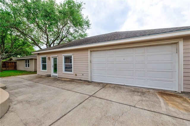 view of front facade with a garage, fence, and concrete driveway