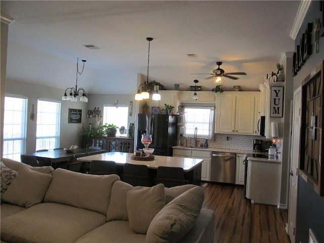 kitchen with appliances with stainless steel finishes, decorative light fixtures, sink, dark hardwood / wood-style flooring, and plenty of natural light