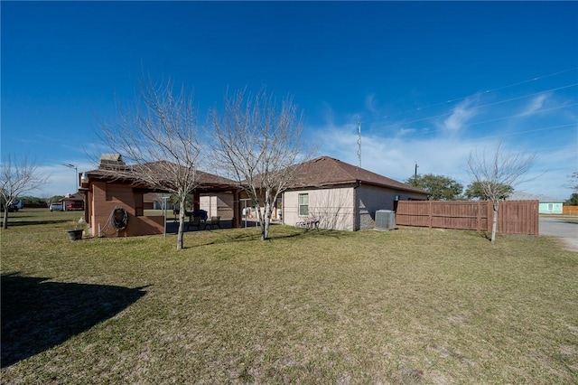 rear view of property with a yard and central AC unit