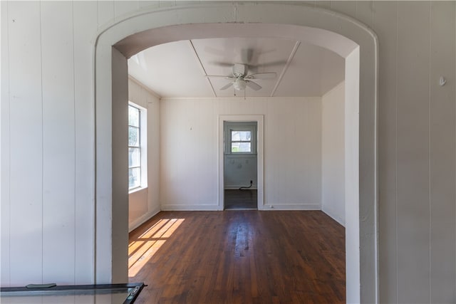 spare room with wood walls, dark hardwood / wood-style floors, and ceiling fan