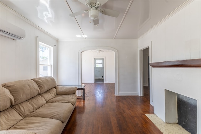 living room featuring wood walls, ornamental molding, a wall unit AC, ceiling fan, and dark wood-type flooring