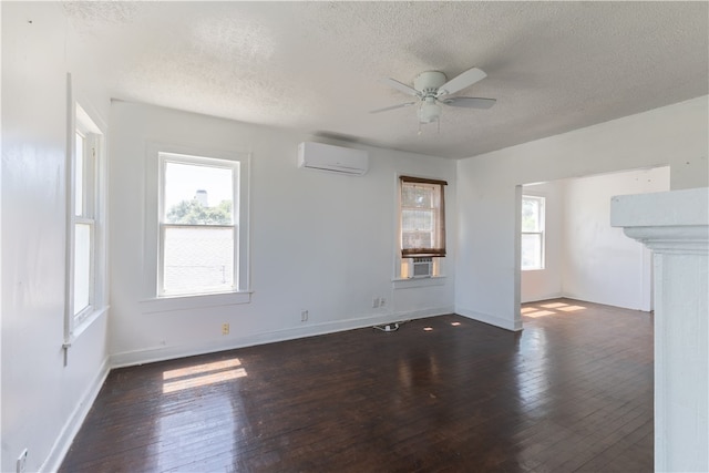 spare room with ceiling fan, a textured ceiling, dark hardwood / wood-style flooring, and a wall mounted air conditioner