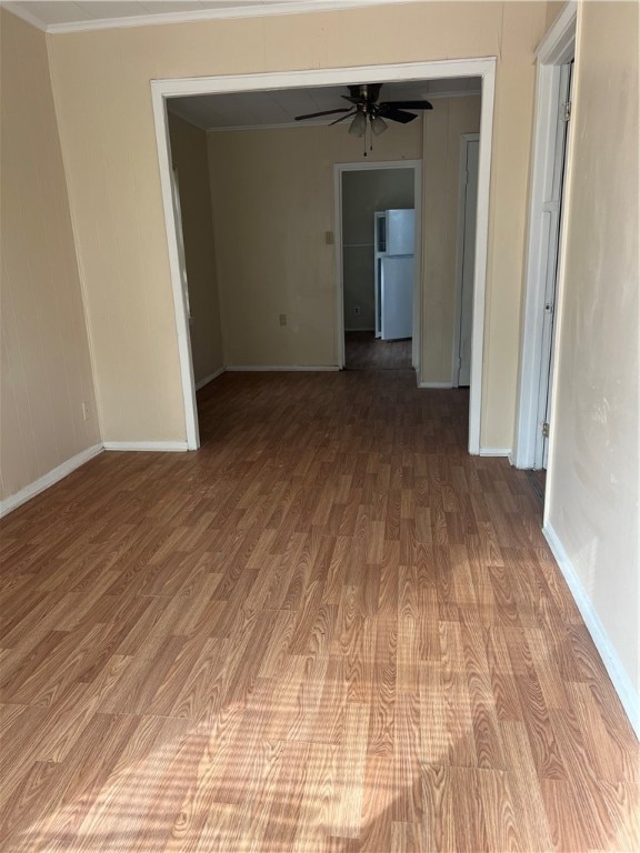 spare room with ceiling fan, wood-type flooring, and ornamental molding