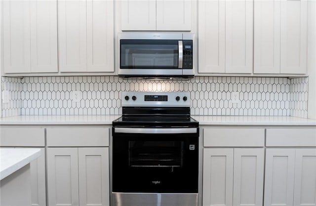 kitchen with white cabinetry, stainless steel appliances, and decorative backsplash