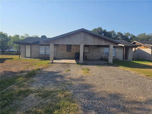 view of side of home with brick siding and a patio
