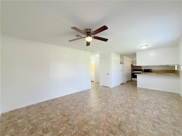 unfurnished living room featuring ceiling fan and baseboards