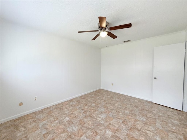 unfurnished room with visible vents, ceiling fan, a textured ceiling, and baseboards