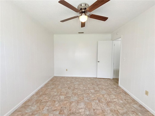 empty room featuring visible vents, a textured ceiling, and baseboards