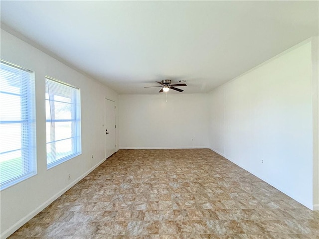 empty room with baseboards and a ceiling fan