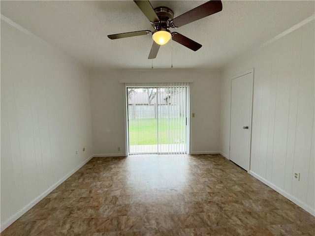 empty room featuring wooden walls, baseboards, a textured ceiling, and tile patterned floors