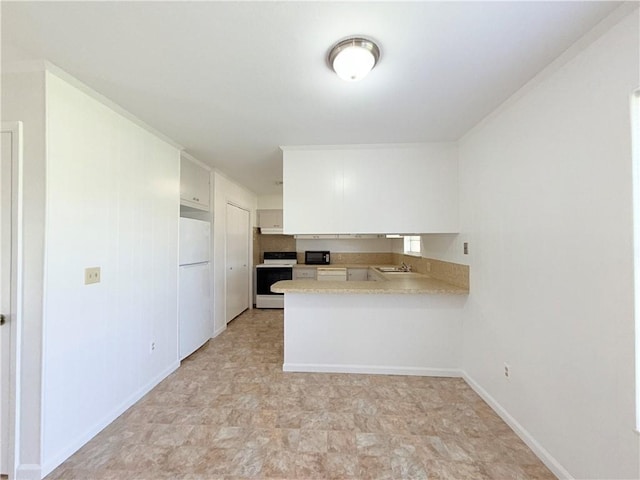 kitchen with range with electric cooktop, white cabinets, freestanding refrigerator, a peninsula, and light countertops
