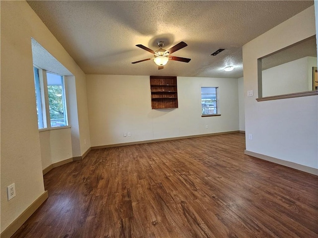 unfurnished room featuring dark hardwood / wood-style flooring, a textured ceiling, and a healthy amount of sunlight