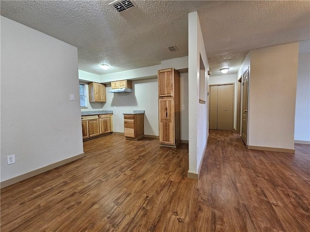 kitchen featuring a textured ceiling and dark hardwood / wood-style floors