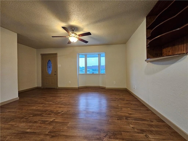 spare room with a textured ceiling, dark hardwood / wood-style floors, and ceiling fan