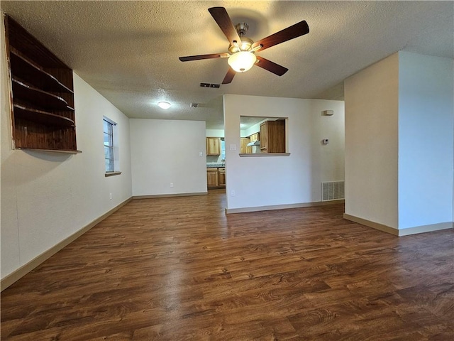 unfurnished living room with dark hardwood / wood-style floors, ceiling fan, and a textured ceiling