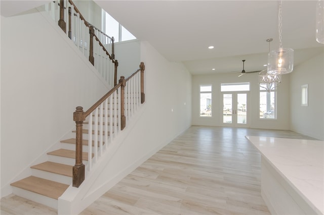 stairs with french doors and wood-type flooring