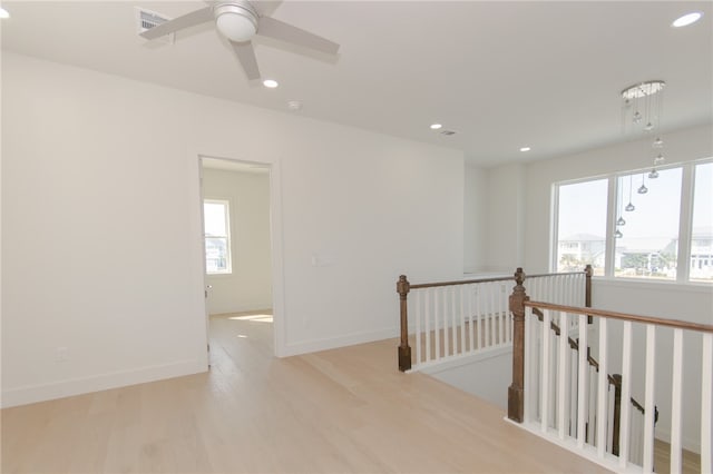 hall with a wealth of natural light and light hardwood / wood-style floors