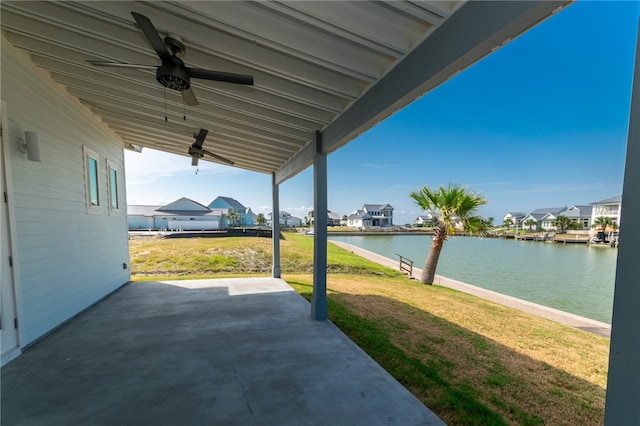 view of patio with a water view and ceiling fan