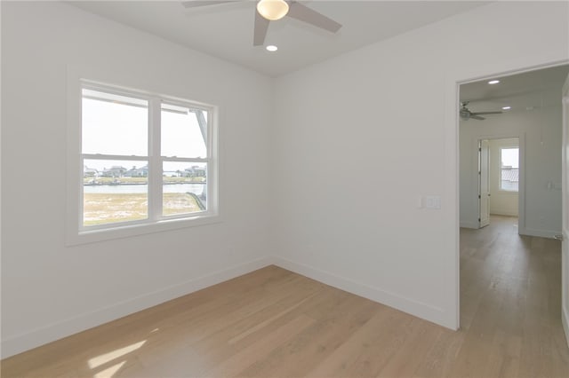 spare room featuring light hardwood / wood-style floors, ceiling fan, and plenty of natural light