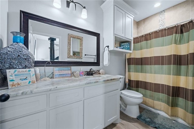 bathroom with curtained shower, wood-type flooring, toilet, and vanity