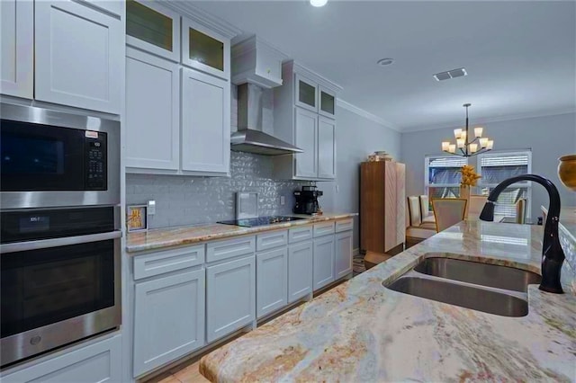 kitchen featuring stainless steel appliances, white cabinetry, sink, and pendant lighting