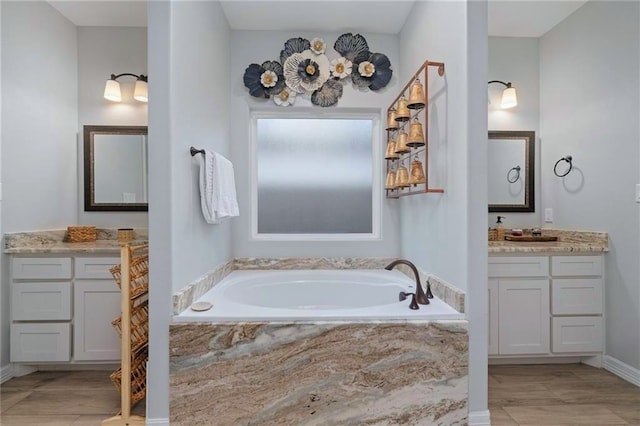 bathroom with a relaxing tiled tub and vanity