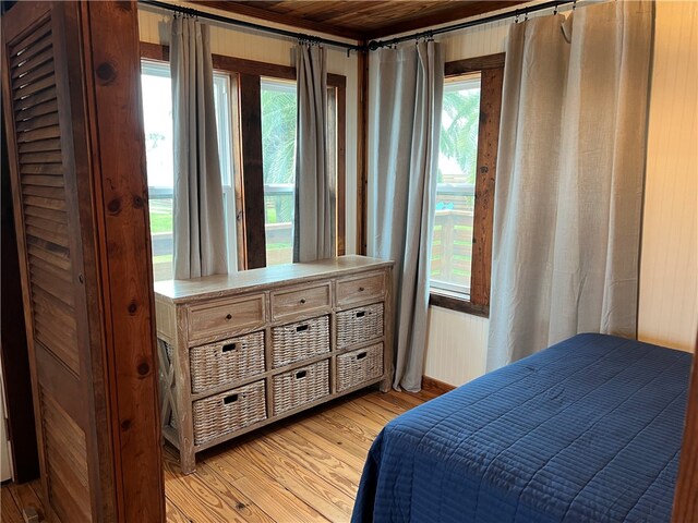 bedroom featuring a barn door, wooden ceiling, and wood-type flooring