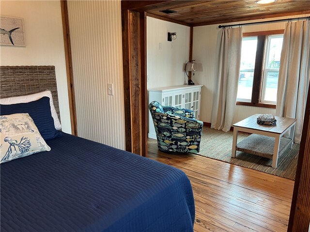 entryway featuring light hardwood / wood-style floors, a barn door, wooden ceiling, and ornamental molding