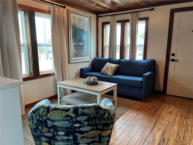 sitting room with a barn door, wooden ceiling, and light hardwood / wood-style floors